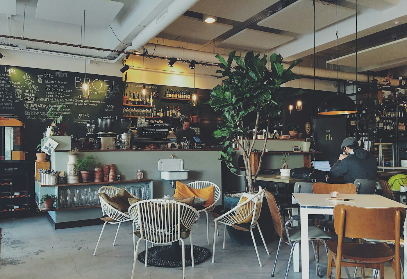A cafe counter, chalkboard menu, and chairs in the seating area
